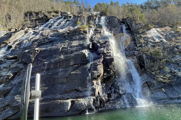 Cascata de uma cachoeira em Bergen, na Noruega, no meio de um passeio por fiorde