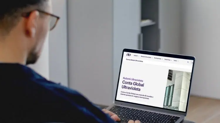 Pessoa utilizando um notebook com a página da Nubank Ultravioleta Conta Global aberta na tela