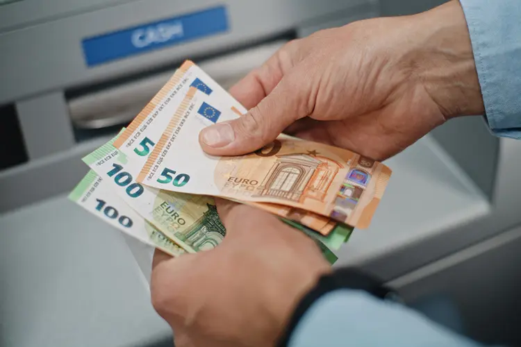 Homem contando notas de euro.