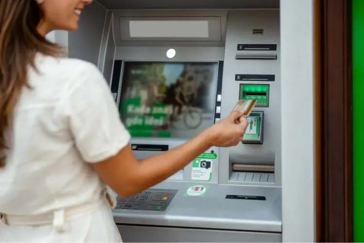 Viajante sacando euros em caixa eletrônico.