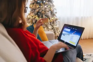 Mulher comprando passagem aérea online com cartão de crédito no site ViajaNet.