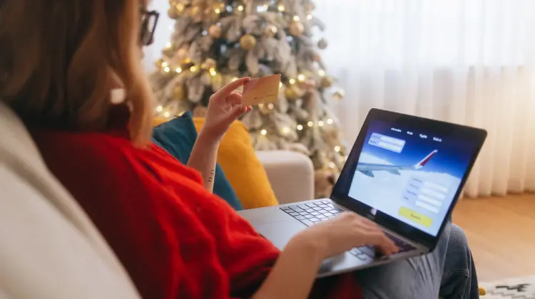 Mulher comprando passagem aérea online com cartão de crédito no site ViajaNet.