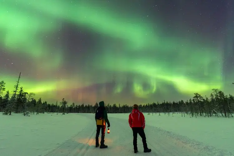 Casal admirando a aurora boreal.