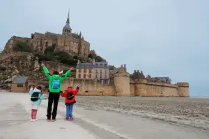 Família na frente do Monte Saint Michel em viagem pela França com crianças