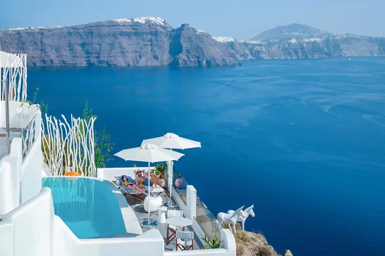 Vista aérea de hotel de luxo em Oia, com vista para o mar Egeu.