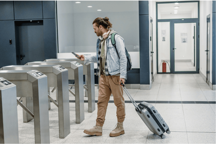 Homem andando com mala de mão no aeroporto