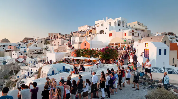 pessoas em oia vendo o por do sol