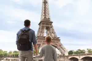 Pai segurando a mão do filho em Paris.