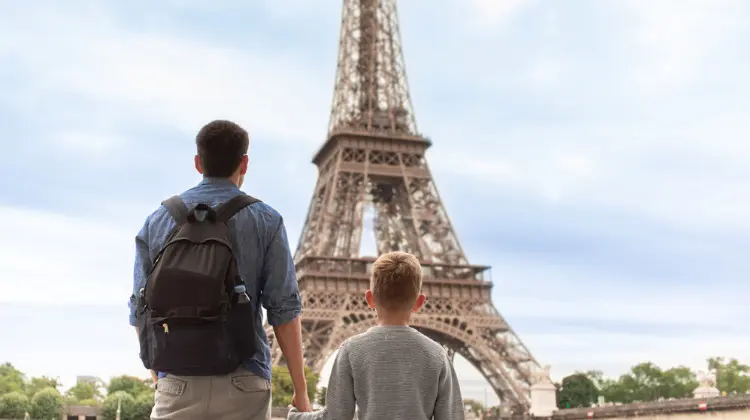 Pai segurando a mão do filho em Paris.
