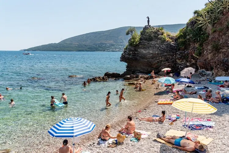 Praia de Montenegro com alguns turistas curtindo a praia em agosto.