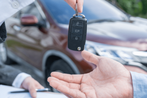 Pessoa entrega uma chave de carro alugado pela Rentcars.