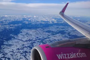 Vista aérea de montanhas nevadas durante voo interno na Europa com a Wizz Air