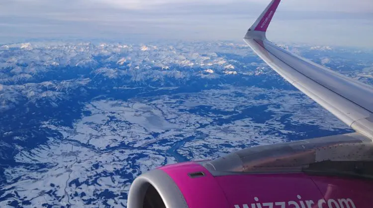 Vista aérea de montanhas nevadas durante voo interno na Europa com a Wizz Air