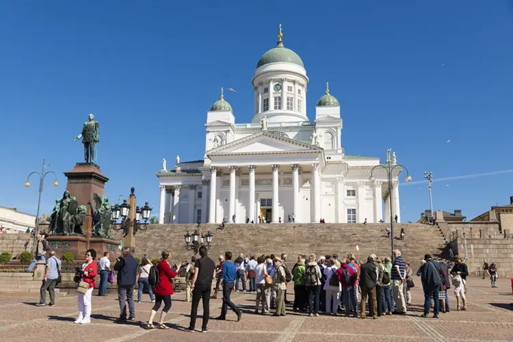 Turistas visitando ponto turístico de Helsinque, capital da Finlândia.