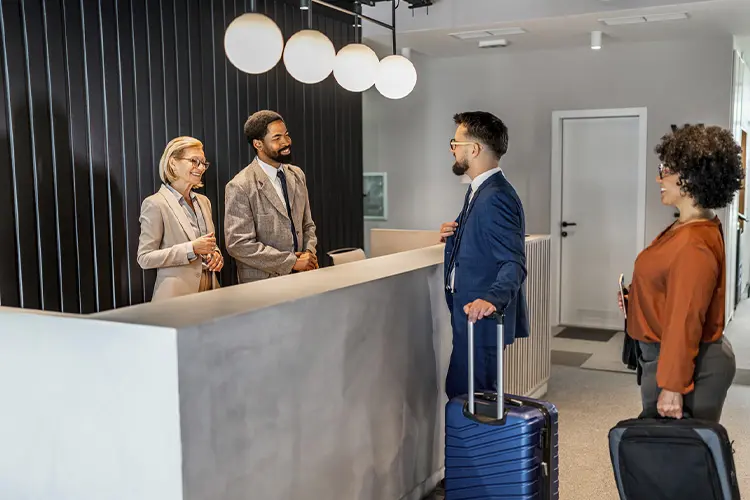 Hóspedes conversam com concierge em hotel