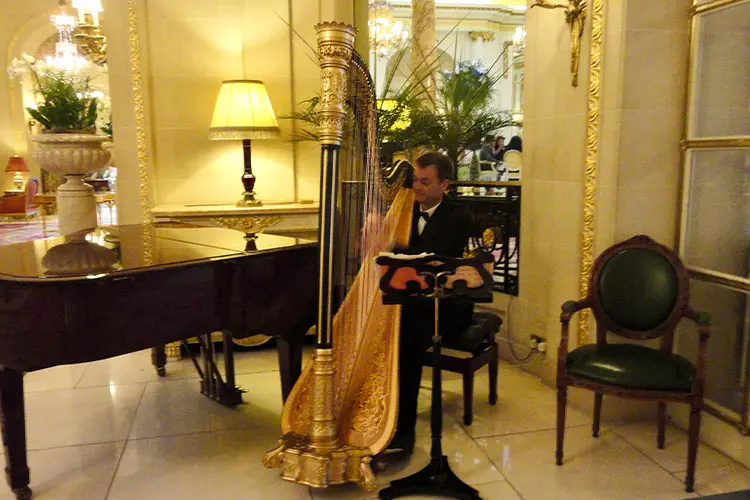 Harpista tocando na entrada do chá no Hotel Ritz