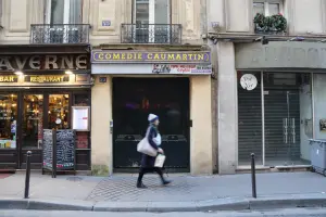 Moradora caminha pelas calçadas de rua parisiense