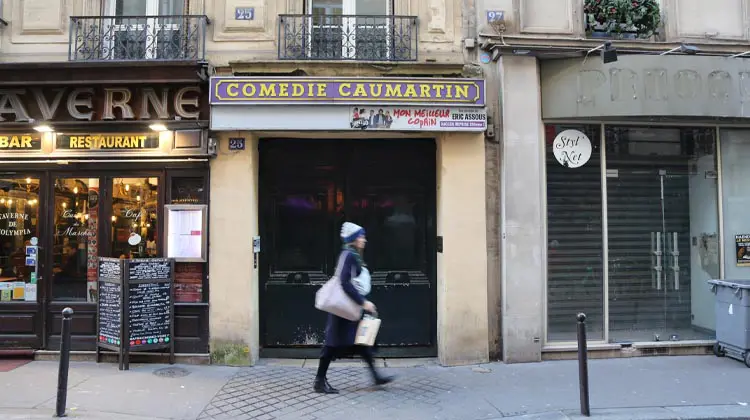 Moradora caminha pelas calçadas de rua parisiense