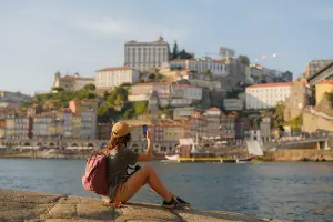 Mulher fotografando a ribeira do Porto, uma das coisas para fazer em Portugal