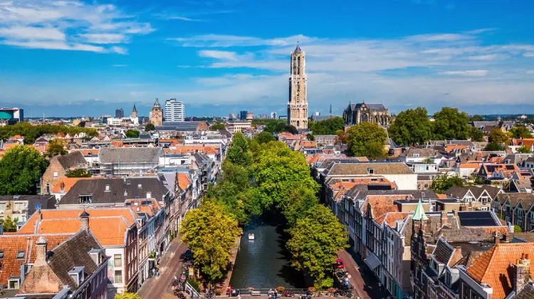 Vista aérea do centro histórico de Utrecht com canais, casas típicas holandesas e a Dom Tower ao fundo.