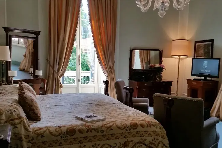 Quarto de suíte standard no hotel Vila D´este com cama imponente e lustre