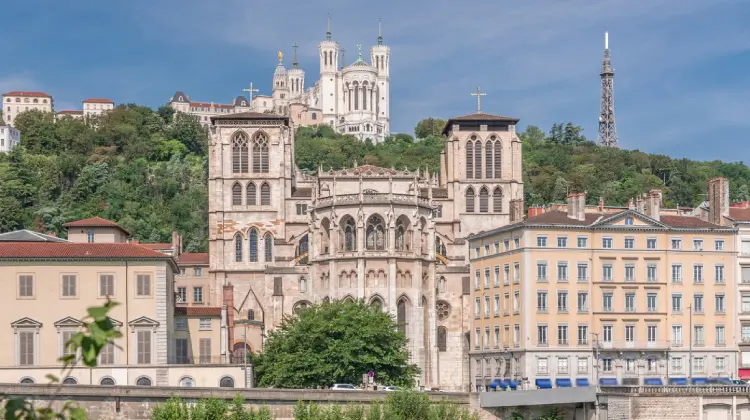 Catedral de São João Batista e Basílica de Notre-Dame de Fourvière refletidas no rio em Lyon, destino de bate e volta na França