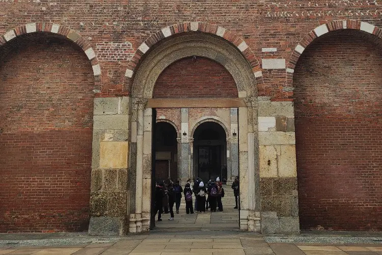 Turistas visitam a Basílica de Sant'Ambrogio durante um city tour em Milão.