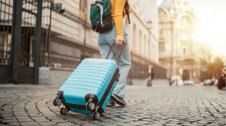 Turista caminhando com sua mala de viagem.