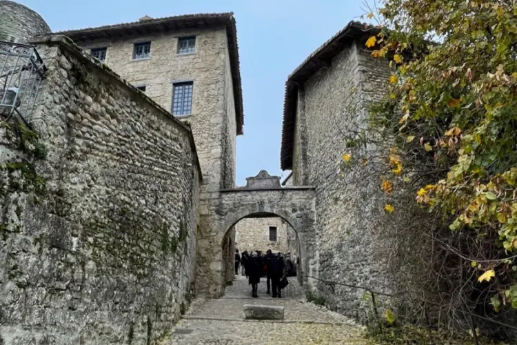 Rua medieval em Pérouges com muros de pedra e construções históricas.