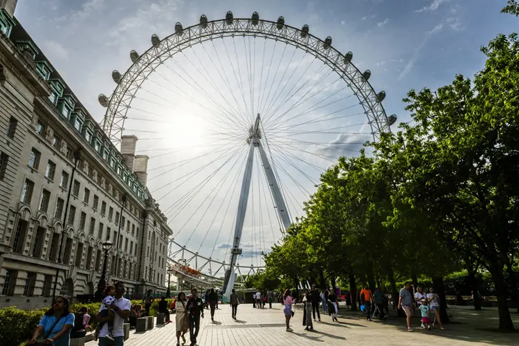Vista da London Eye com turista passeando pela área.