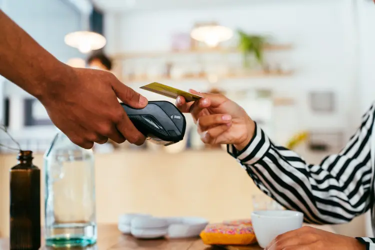 Mulher pagando conta com cartão de crédito