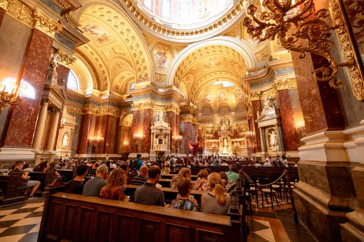 Interior da Basílica de Santo Estêvão em Budapeste com cúpula decorada, colunas de mármore e detalhes dourados do estilo neoclássico