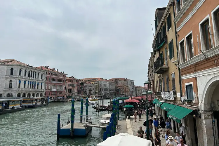 Canal próximo à Ponte Rialto em Veneza, com vários estacionamentos para gôndolas.