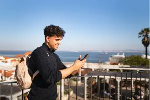 Homem usando o celular em dia de sol
