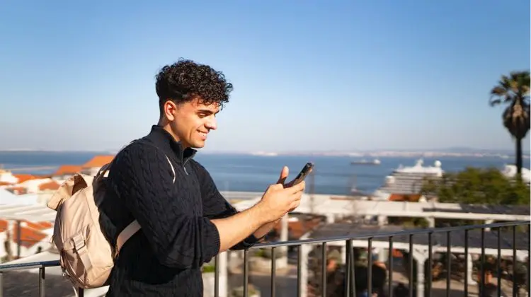 Homem usando o celular em dia de sol