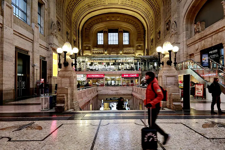 Interior da estação de Milano Centrale, região de intenso fluxo de pessoas.