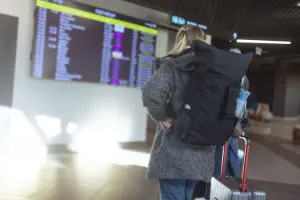 Passageira em aeroporto, com mochila para viagem de avião.