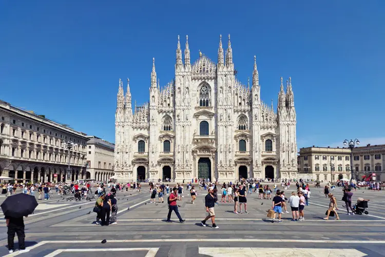 Pessoas em frente a praça da Duomo de Milão, na Itália.