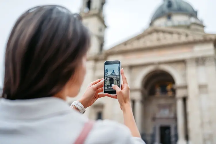 Turista fotografando a Basílica de Santo Estêvão em Budapeste durante a visita ao ponto turístico