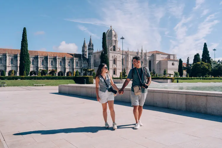 Casal em lua de mel em Portugal passeia pelo Mosteiro dos Jerônimos em Belém, Lisboa.