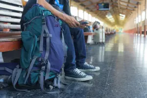 Homem sentado ao lado do mochilão para viagem