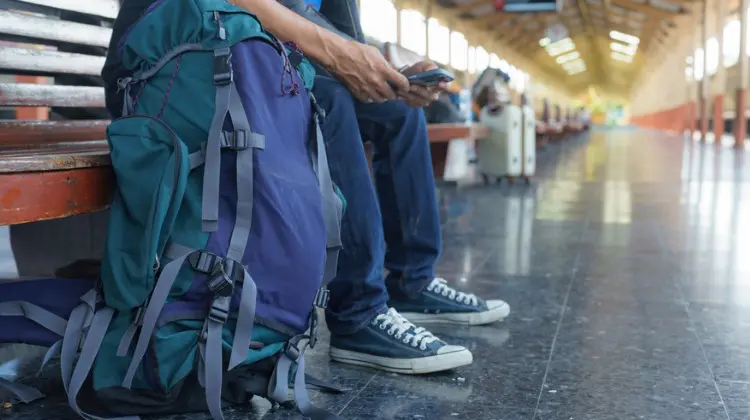 Homem sentado ao lado do mochilão para viagem