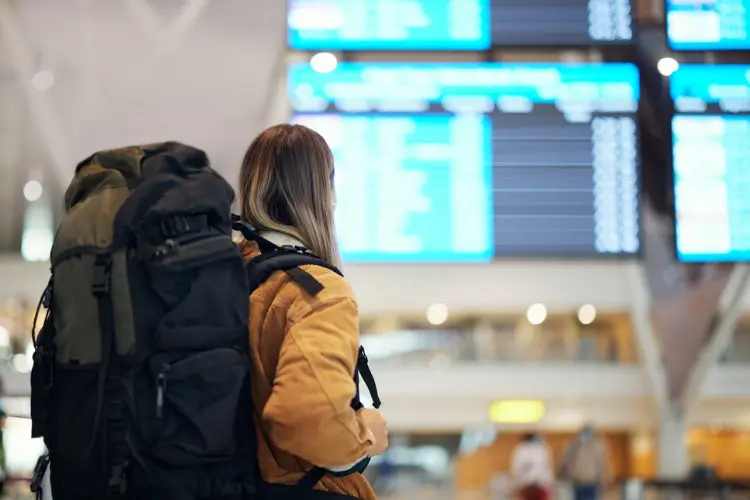 Mulher com mochilão para viagem no aeroporto