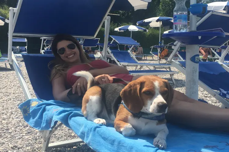 Mulher com seu beagle na praia do Lago de Garda durante uma viagem com cachorro na Europa