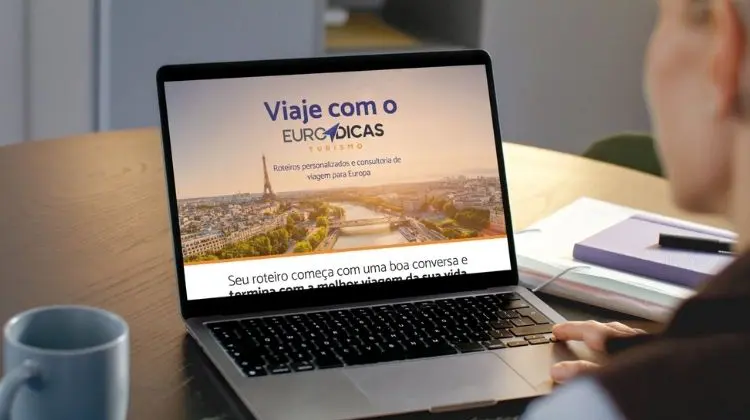 Pessoa usando notebook com a página da Euro Dicas Turismo aberta para planejar viagem