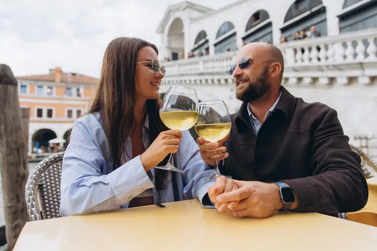 Casal brindando em frente à Ponte de Rialto em Veneza, na Itália.
