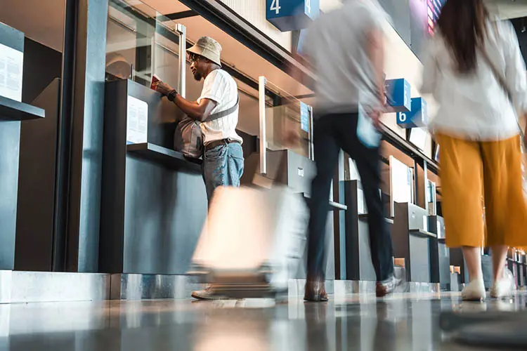 Passageiro verificando documentos de viagem em guichê no aeroporto