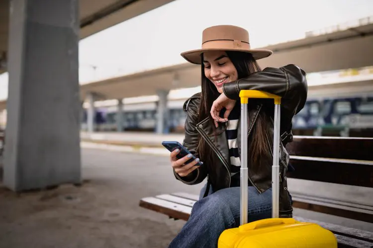 Turista com celular na mão em estação da Grécia