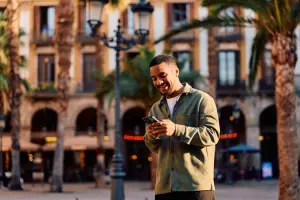 Turista com celular na mão usando a internet da Holafly em Barcelona