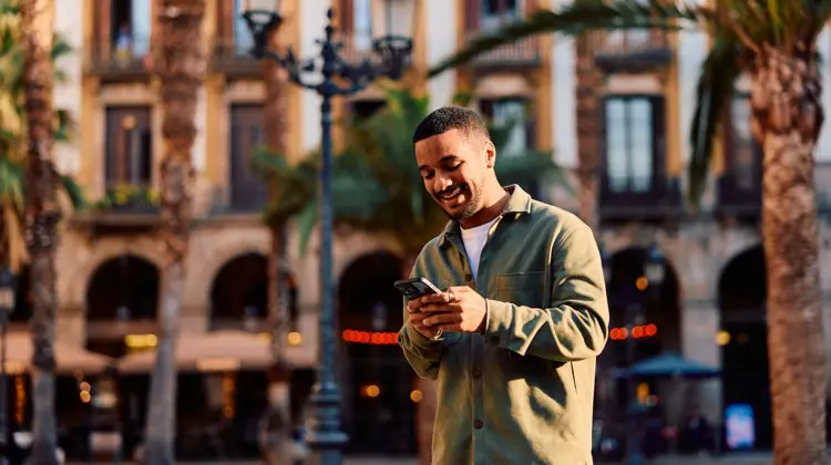 Turista com celular na mão usando a internet da Holafly em Barcelona